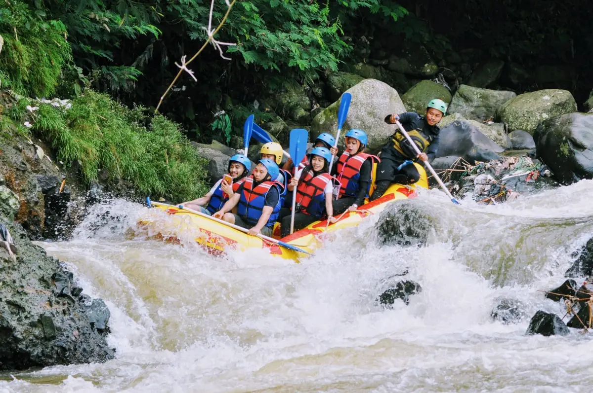 Perahu kuning melintas di antara batu-batu besar