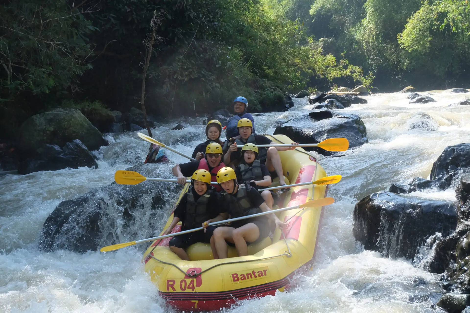 Perahu kuning menyusuri sungai berbatu