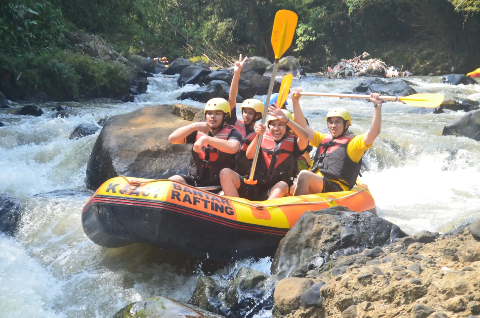 Perahu kuning menyusuri sungai berlatar hijau