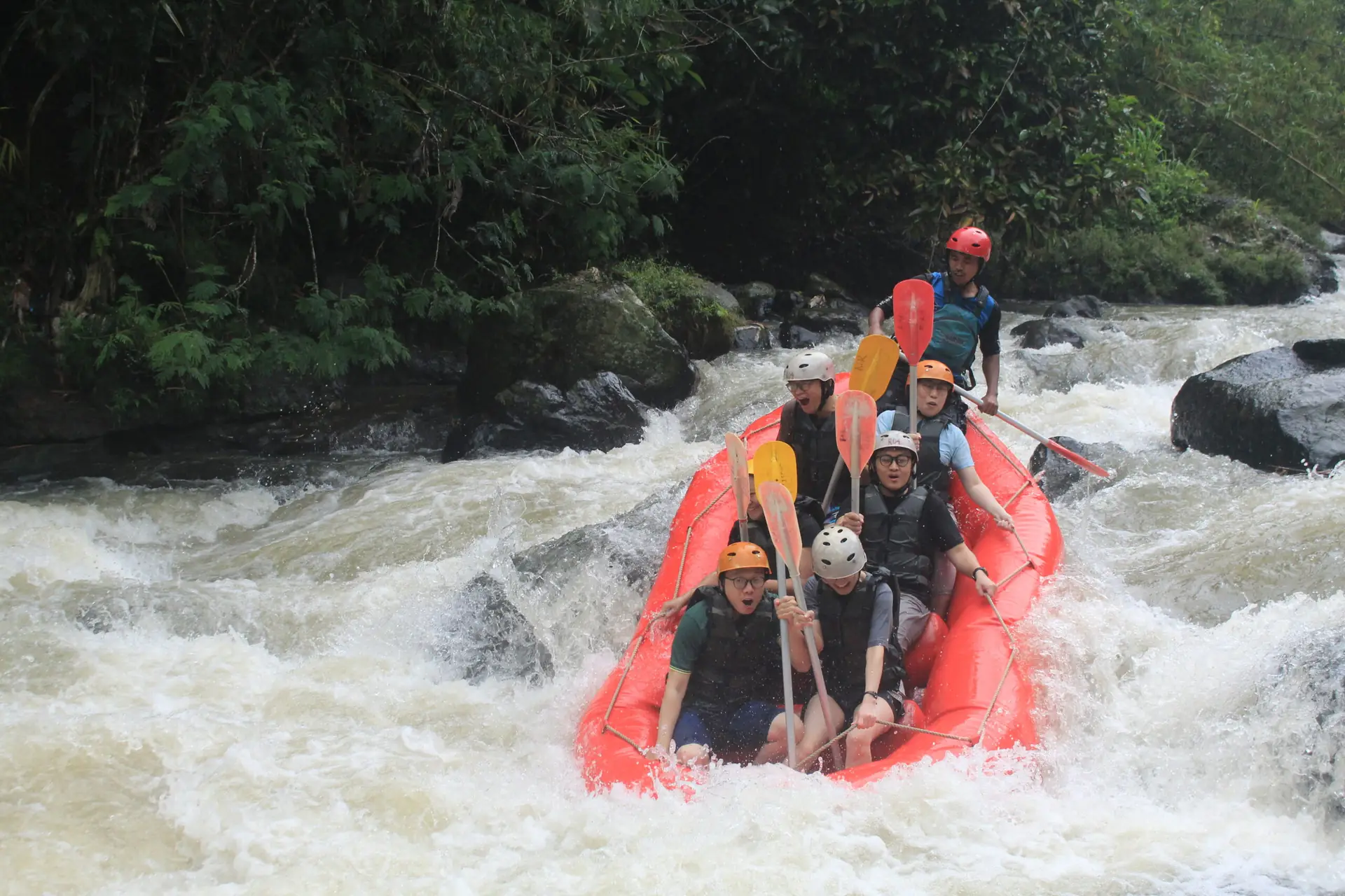 Perahu merah di arus jernih berbatu